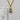 A gold chain necklace with an oval bezel pendant featuring a clear faceted gemstone and small accent stones. A chic statement necklace for day or night.