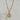 A gold-tone pendant necklace featuring a circular medallion with an angel and heart design, accented with small clear stones, hanging from a gold chain.