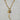 Gold-tone mixed-link statement necklace featuring a long textured curved horn pendant, celestial sun and moon coin, faceted labradorite gemstone, and crystal charm.
