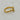 A gold ring with a rough, organic-shaped bezel holding a clear oval gemstone.