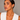 A model wearing gold geometric triangle hoop earrings with a hinged clasp.