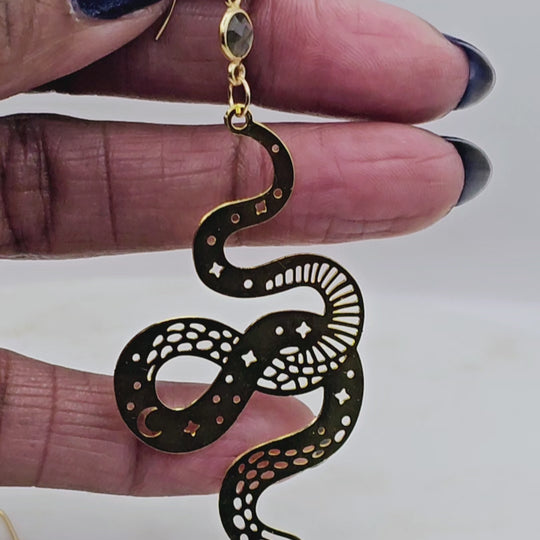 Long dangling laser cut moon and stars on a gold snake with a gem stone.