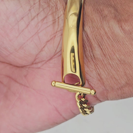 18kt gold stainless steel, non-tarnish, half bangle half link chain and a clear cz charm. Unique design and statement piece.