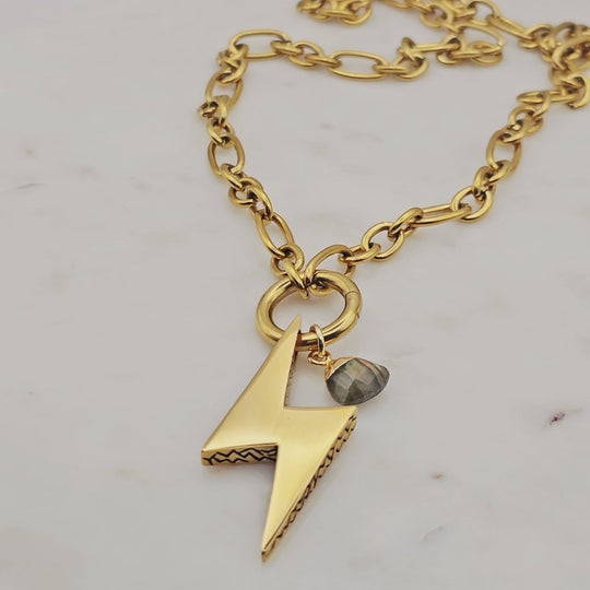 18kt gold plated over stainless steel. Large gold lightening bolt with a genuine labradorite gem stone. A lightening bolt symbolizes inner strength. Chunky statement necklace. Unique jewelry style.