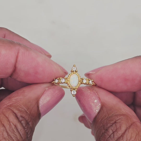 Vintage inspired oval shaped opal gemstone ring with cz stones. 18kt gold plated stainless steel. Non tarnish and waterproof. Very unique setting. And great to wear with complimenting rings.