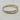 A pair of gold and silver bangle bracelets, each featuring a row of baguette-cut clear stones, displayed on a light marble surface.