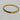 Polished gold-tone bangle bracelet with a sleek row of faceted black crystals set across the front.