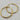 Large gold-tone hoop earrings featuring a polished, rounded tubular design with a smooth high-shine finish and hinged wire closures.