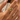 Gold wrap ring with organic textured design and emerald-green or clear  marquise stone held between a model’s fingers.