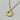 A gold pendant necklace with a detailed round medallion inspired by the night sky, accented with sculpted stars, a sparkling crystal crescent, and a small striking green aventurine cabochon accent.