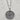 A silver compass pendant necklace with an antiqued finish, resting on a light gray marble surface.