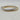 Two slim bangle bracelets overlapping on a light marble surface. One bracelet is silver-toned with a row of clear stones, and the other is gold-toned with matching stone accents.