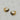 A pair of gold pavé huggie hoop earrings with small black stones