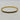 A gold bangle bracelet with a black inlay, photographed on a light marble surface.