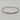 A slim silver bangle bracelet featuring a row of baguette-cut clear stones along the front, displayed on a light marble surface.